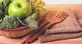 Close up green apple with mixed green vegetable in  basket and wooden fork and spoon for healthy organic green food concept Royalty Free Stock Photo