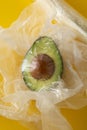Close up green Avocado in plastic bag for sale or fridge. Effect Destroyer of the use of plastic bags. Zero waste concept. Avocado
