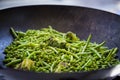 Close up on green beans, broccoli and peas are cooked in a big iron pan Royalty Free Stock Photo