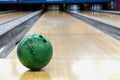 Close-up of green bowling ball against background of empty lanes in bowling alley Royalty Free Stock Photo