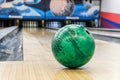 Close-up of green bowling ball against background of empty lanes in bowling alley Royalty Free Stock Photo