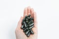 Close-up of green capsules pills in female hand isolated on white background. Royalty Free Stock Photo