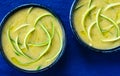Close up of green cold zucchini soup with swirls of zucchini strips