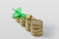 Close-up of green dart on raising coins stack - Money growth concept