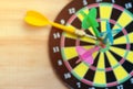 Close up green darts arrow on the target center of dartboard for business goal concept - Flay lay Royalty Free Stock Photo