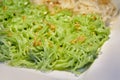 Close-up green egg noodles on the white plate with fried garlic on top Royalty Free Stock Photo