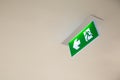 Close up the green emergency fire exit sign or fire escape on the building ceiling Royalty Free Stock Photo