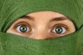 green eyes of a girl with face wrapped in a green scarf Royalty Free Stock Photo