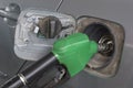 Close up green fuel nozzle. and car at gas station