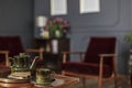 Close-up of green jug, tea cup and cookies placed on table in th