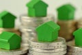 Close-up of green miniature houses on coin stacks - Concept of real estate investment, mortgage, home insurance and loan, eco- Royalty Free Stock Photo