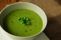 Close up of green pea soup in bowl on wooden table Royalty Free Stock Photo