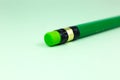 Close up green pencil with eraser on the green background. Minimalism, original and creative photo