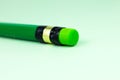 Close up green pencil with eraser on the green background. Minimalism, original and creative photo