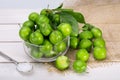 Close Up Of Green Plums Or Greengage in a glass bowl and sprinkle of salt Isolated On White wooden Background, Popular Spring