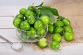 Close Up Of Green Plums Or Greengage in a glass bowl and sprinkle of salt Isolated On White wooden Background, Popular Spring