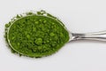 Close-up of Green Powder in a Spoon on White Background Royalty Free Stock Photo