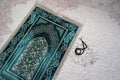 Close-up green prayer rug and rosary, praying in the month of ramadan