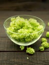 Close up of green ripe hop cones in a glass bowl over dark rusti Royalty Free Stock Photo