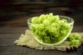 Close up of green ripe hop cones in a glass bowl over dark rustic wooden background. Beer production ingredient. Royalty Free Stock Photo