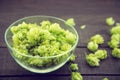 Close up of green ripe hop cones in a glass bowl over dark rustic wooden background. Beer production ingredient. Royalty Free Stock Photo