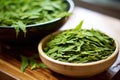 close-up of green tea leaves steeping in a gaiwan