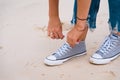 Close up of grey sneakers with white shoelaces. Woman lacing up tennis shoes