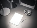 Grey table with switched-on lamp, handcuffs and paper sheet, 3d rendering. Royalty Free Stock Photo