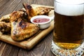 Close-up of grilled chicken wings and beer in glass Royalty Free Stock Photo