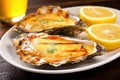 close-up of a grilled oyster with garlic sauce and a lemon wedge