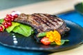 Close up grilled steak with fresh salad on a black plate Royalty Free Stock Photo