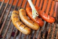 Close up of grilling sausages on barbecue grill with a long white onion. BBQ in the garden. Bavarian sausages Royalty Free Stock Photo