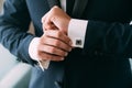 Close-up groom hands puts on cufflinks. Elegant gentleman clothers, white shirt