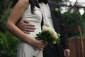 Close up groom holding bride with bouquet by waist concept photo