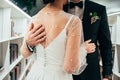 Close-up groom hugs his pretty bride in white dress . .. newlyweds dance the first dance. back view Royalty Free Stock Photo