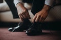 Close up of groom putting on a shoes, in the morning before wedding, tying shoelaces. Businessman getting ready for work Royalty Free Stock Photo