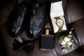 Close-up of the groom's accessories: bow tie, shoes, boutonniere, watch, perfume. Wedding set. Stylish business