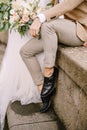 Wedding in Florence, Italy. Close-up of the legs of the groom in light short pants and black leather shoes, the bride in Royalty Free Stock Photo