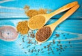 Ground cumin in a spoon and whole cumin on the wooden background. Royalty Free Stock Photo