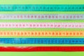 Close up of a group of colorful measure tapes lying in rows as a background. Diet concept on green background Royalty Free Stock Photo