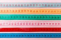 Close up of a group of colorful measure tapes lying in rows as a background. Diet concept on pink background Royalty Free Stock Photo