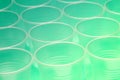 Close up of a group of empty translucent plastic cups, ordered on a turquoise colored surface. Shallow depth of field