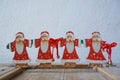 Close up of group of Father Christmas on a used cracky wooden element in front of a white wall