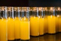 Close up group of fresh pineapple juice in small glass bottles, cold fresh pineapple juice in glass container on stainless steel Royalty Free Stock Photo