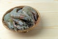 Close up group of fresh raw pacific white shrimp in bamboo bowl on wooden table Royalty Free Stock Photo