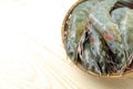 Close up group of fresh raw pacific white shrimp in bamboo bowl on wooden table Royalty Free Stock Photo