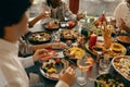 Close up of group of happy young friends is drinking wine and eating during home party together Royalty Free Stock Photo