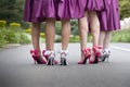 Close up of group of ladies wearing colourful bow heel shoes on tarmac