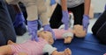 Close up of group of multiethnic people during the first aid training with instructor showing on manikin how to do Royalty Free Stock Photo