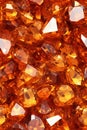 Close up of a group of orange gemstones on a white background